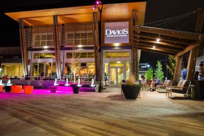 The fountains outside Davio's King of Prussia lit with magenta lights as diners enjoy the evening on the patio